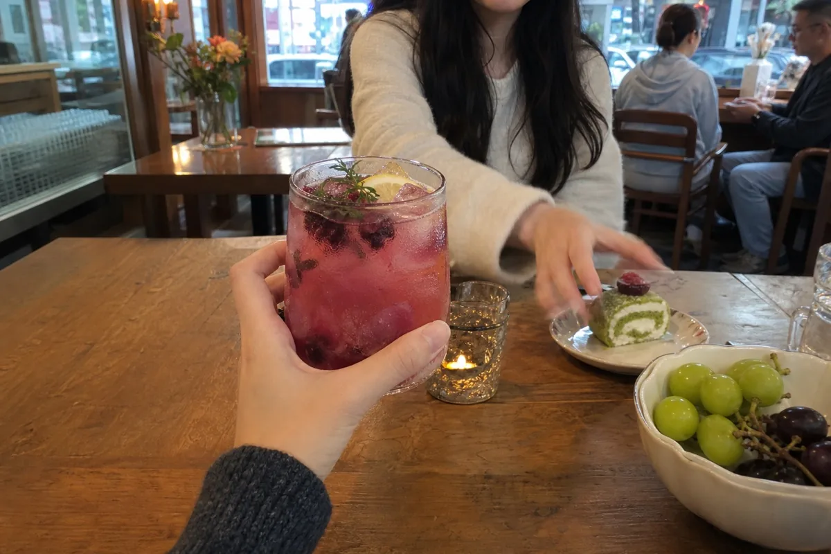 年轻人在咖啡店用手机随手拍下饮品与甜点体验