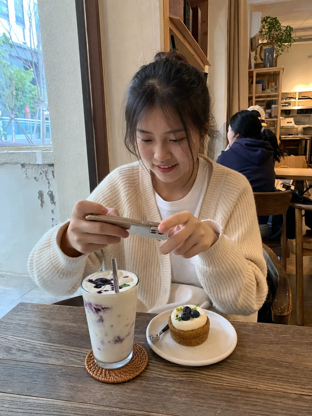 中国女大学生在校园周边咖啡店用手机记录探店体验